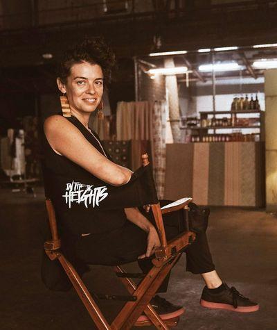 Quiara sitting and smiling in a director's chair on a movie set