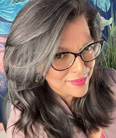 headshot of Jo smiling with colorful mural in background